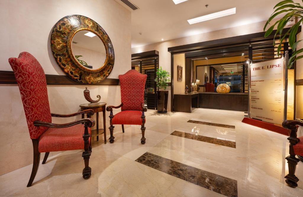 a living room with two chairs and a mirror at The Eclipse Boutique Suites in Abu Dhabi