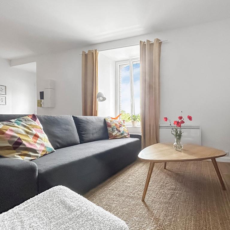 un salon avec un canapé bleu et une table dans l'établissement Escapade paisible Proche Rennes, à Pont-Péan