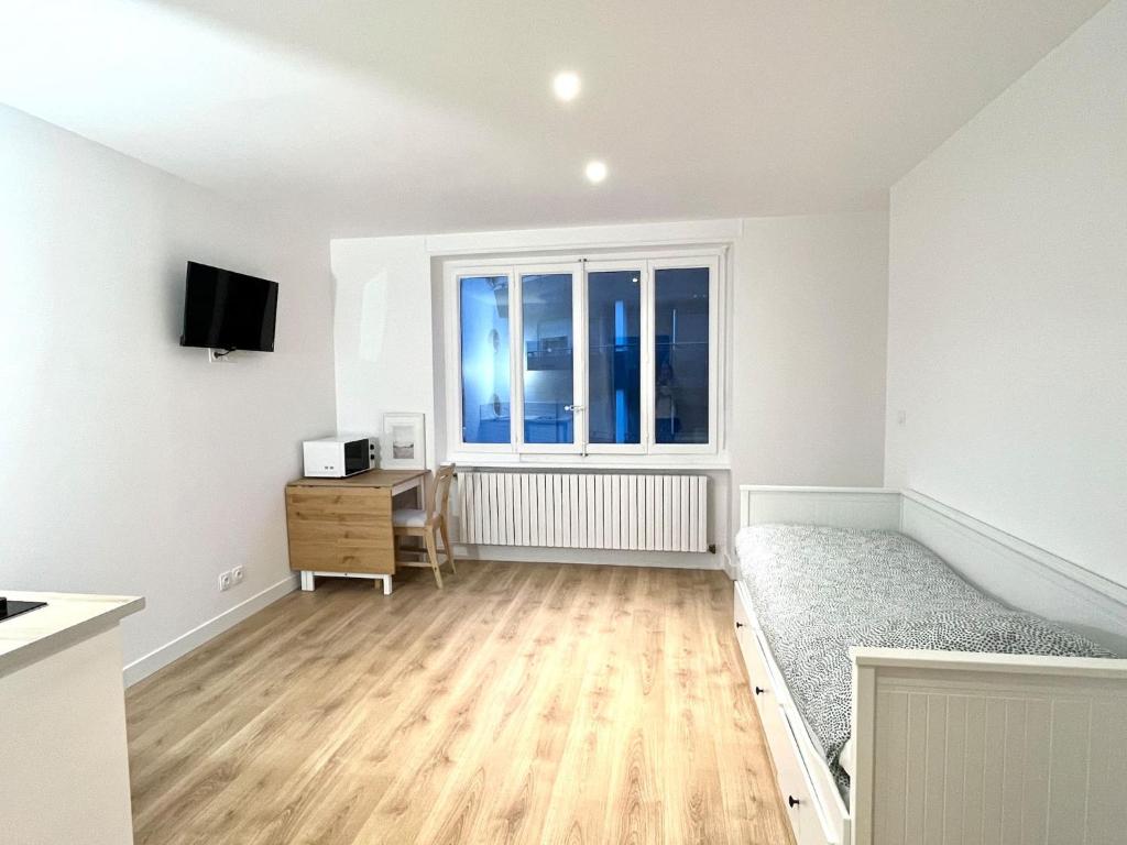 an empty living room with a bed and a window at M010 Marquer joli studio proche de la gare in Annemasse