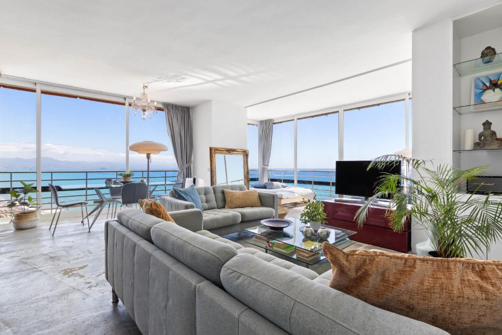 a living room with a couch and a table at Casa Sol - Impresionantes vistas al mar in Torremolinos
