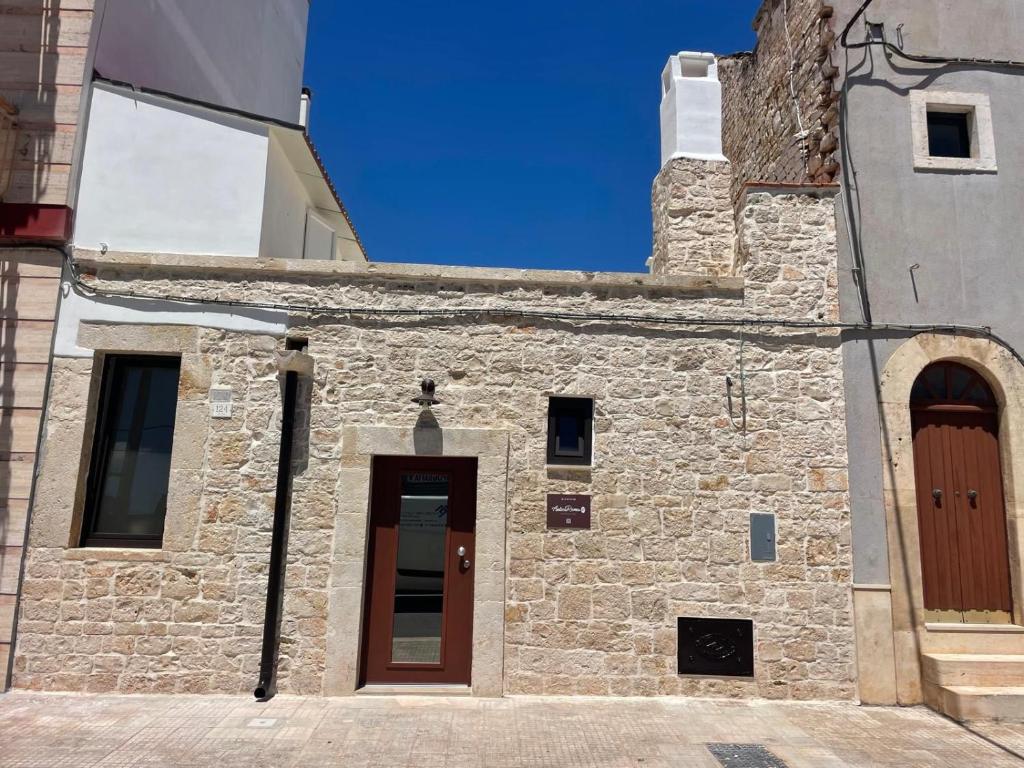 an old stone building with a brown door at Antica Roma 122 in Sammichele di Bari