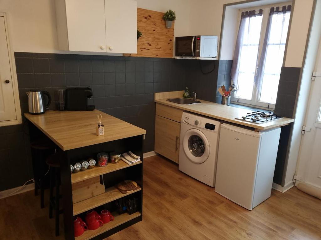a kitchen with a sink and a washing machine at Quincey Village House in Quincey