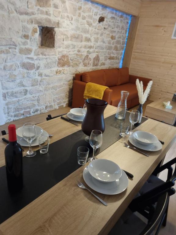 une table en bois avec des assiettes et des verres à vin dessus dans l'établissement Quincey Village House, à Quincey