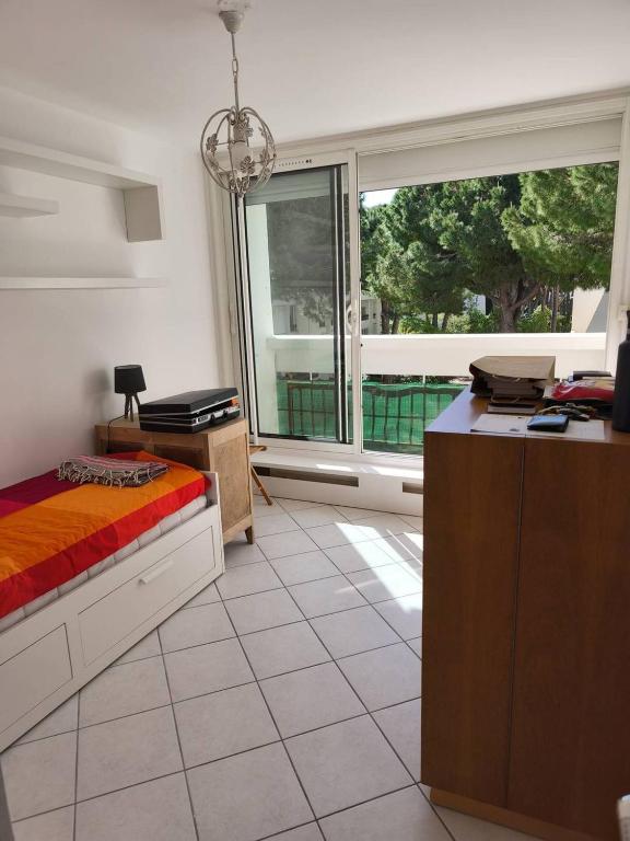 une chambre avec un lit, un bureau et une fenêtre dans l'établissement Au centre ville, appartement t4 climatisé avec parking N72, à La Grande Motte