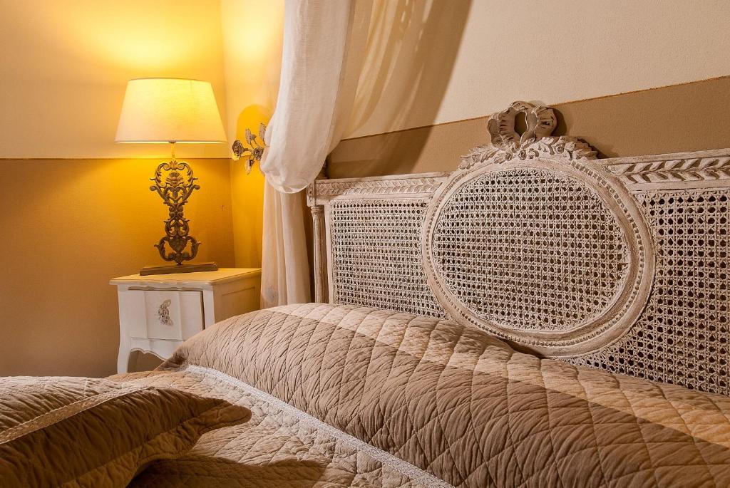 ein Schlafzimmer mit einem weißen Bett und einer Lampe in der Unterkunft Casa Monsignore in San Giovanni in Marignano