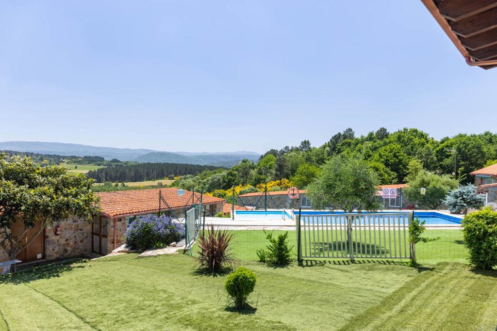 a garden with a fence and a swimming pool at Casa Tunino in Monforte de Lemos