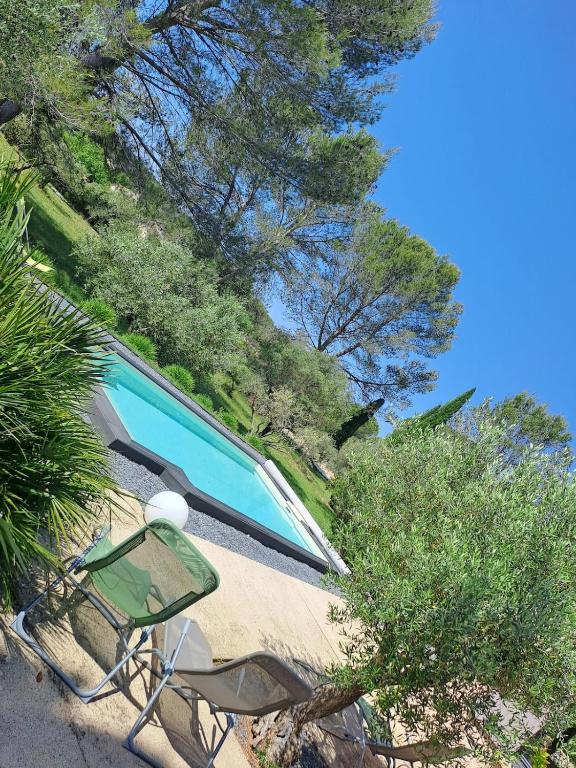 - une piscine avec 2 chaises et des arbres dans l'établissement Vue imprenable sur les oliviers!, à Langlade