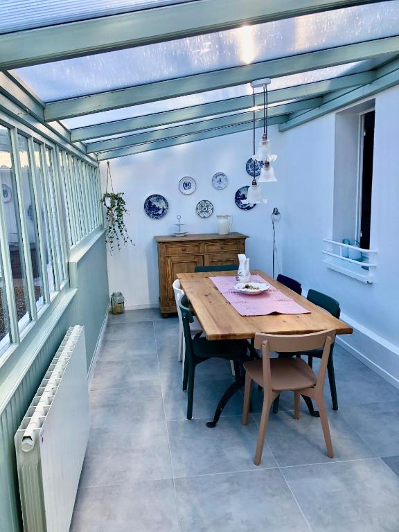 une salle à manger avec une table et des chaises en bois dans l'établissement Le Gîte de la Tannerye, au Tilleul