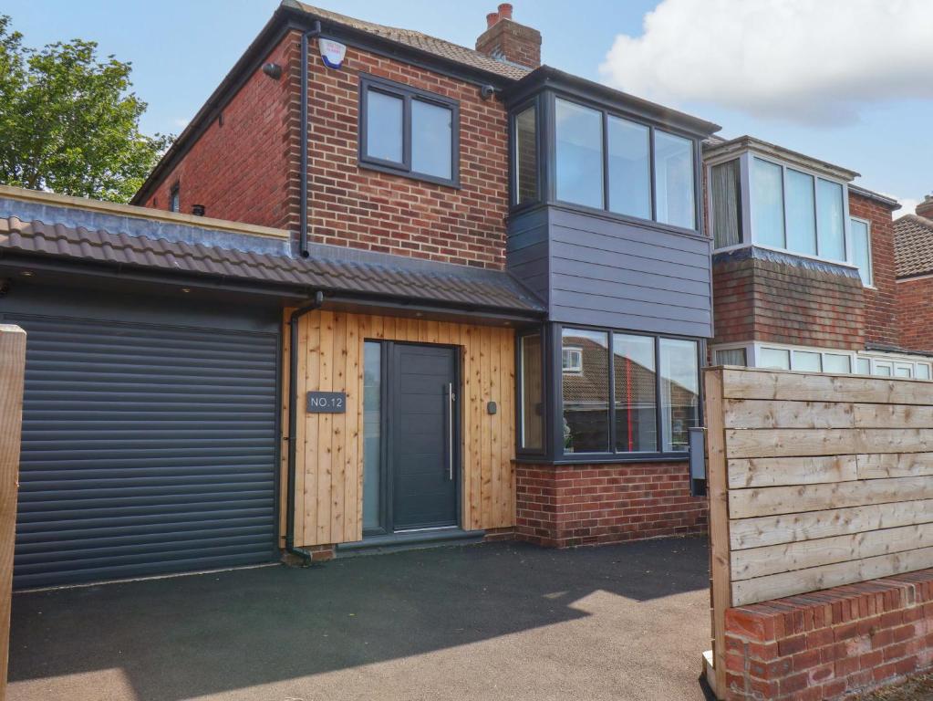 una casa de ladrillo con garaje y puerta en 12 Hunley Avenue, en Saltburn-by-the-Sea