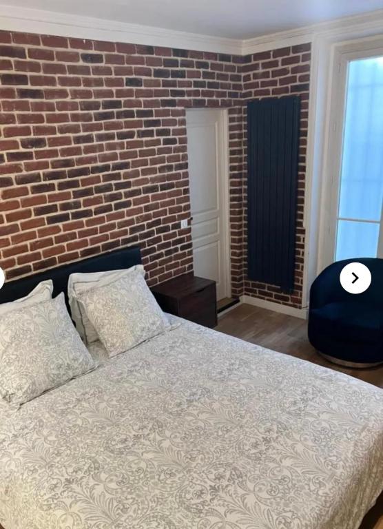 une chambre avec un mur de briques et un lit dans l'établissement Sara House, à Paris