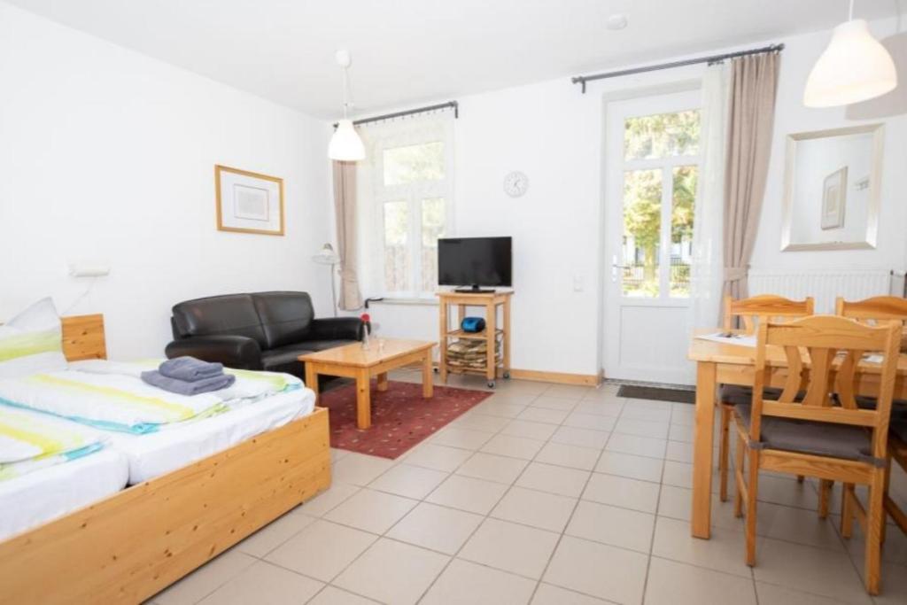 a living room with a bed and a table at Ferienwohnung Forsthaus am Brocken, 35 qm, 1 Wohn-Schlafzimmer F1 in Ilsenburg