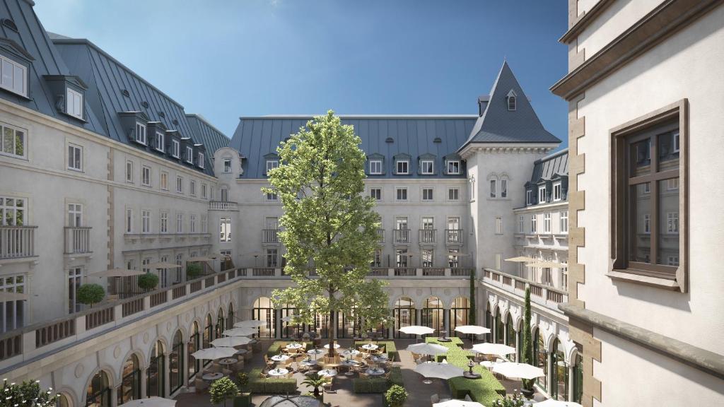 een binnenplaats in een gebouw met tafels en parasols bij The Florentin by Althoff Collection in Frankfurt am Main