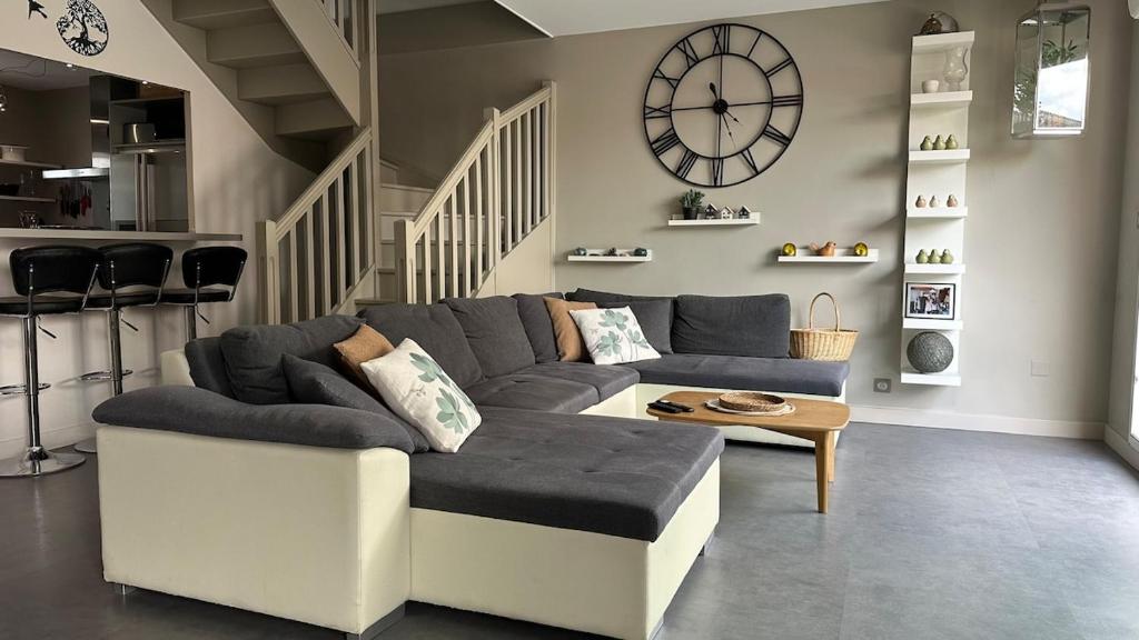 un salon avec un canapé et une horloge au mur dans l'établissement Maison avec jacuzzi proche centre, à Saint-Rémy-de-Provence