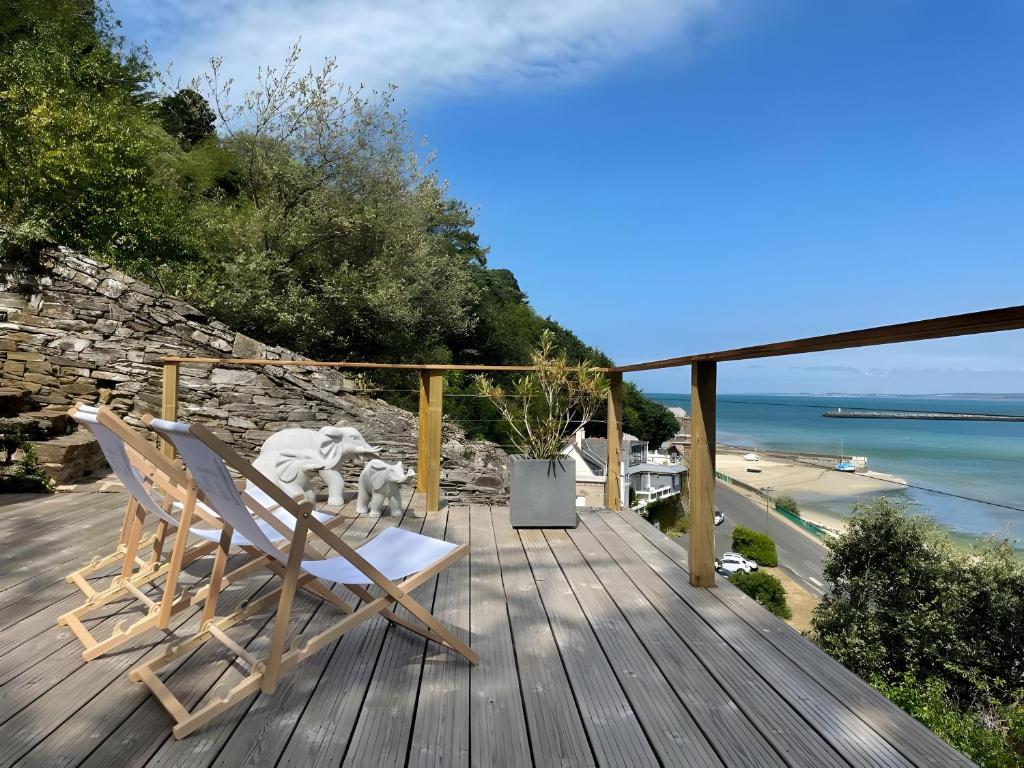 a deck with two chairs and a view of the ocean at La Maison Du Phare in Plérin
