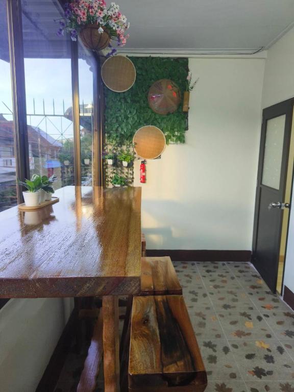 a dining room with a wooden table and a window at AP House in Sathani Hat Yai