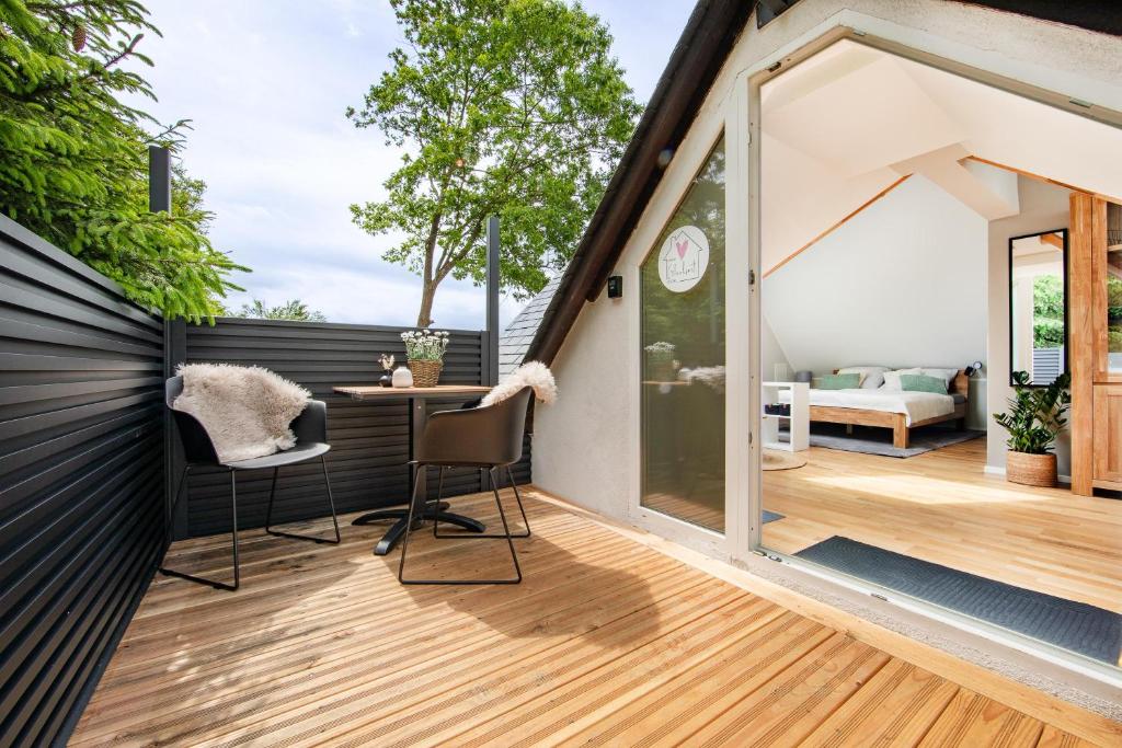 a room with a balcony with a table and chairs at Kleiner Glücksort in Gillenfeld