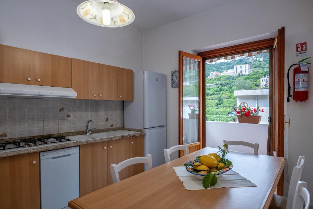 a kitchen with a table with a bowl of fruit on it at Casa Nonna Angela- Relax & Parcheggio Gratuito in Minori