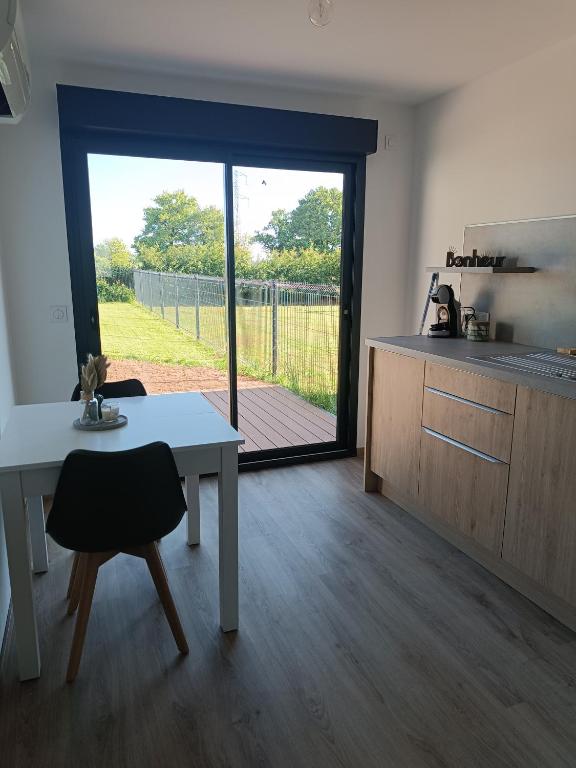 une cuisine et une salle à manger avec une table et une fenêtre dans l'établissement Maison studio de jardin, à Naucelles
