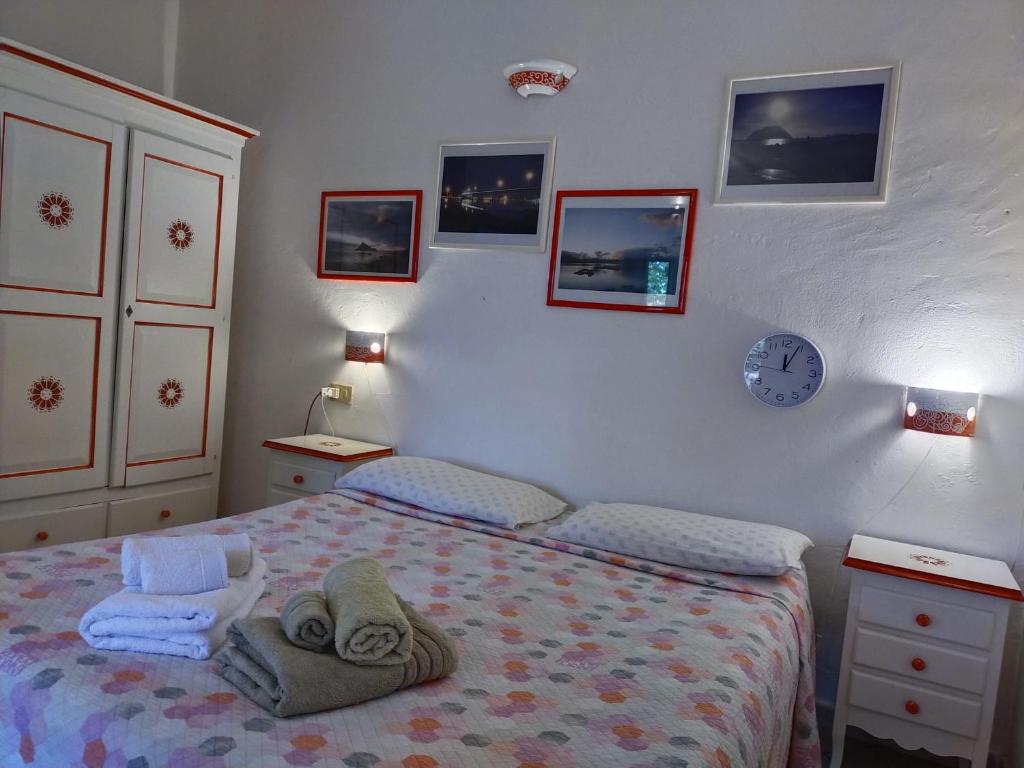 a bedroom with a bed and a clock on the wall at B&B La Taerra in Porto San Paolo