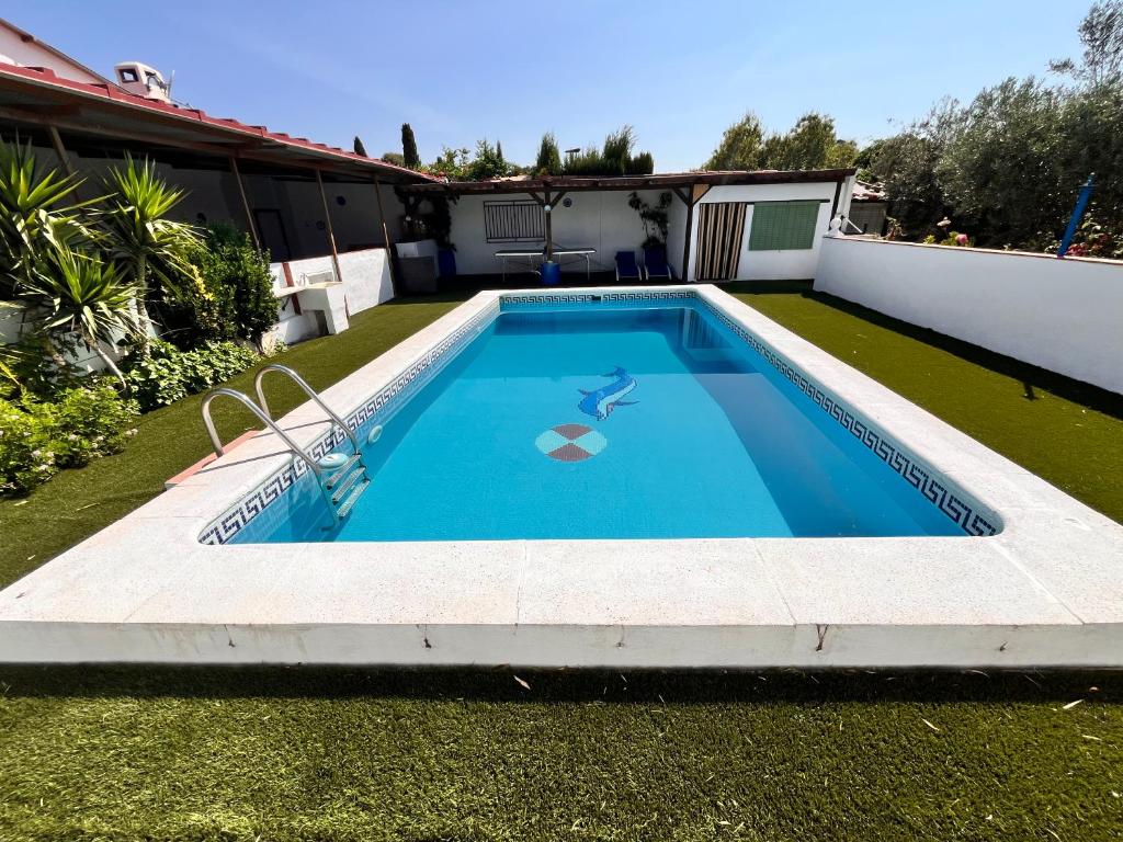 a swimming pool in the backyard of a house at Cortijo Candela in Granada