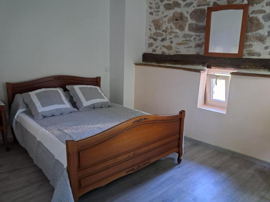 une chambre avec un lit et un miroir au mur dans l'établissement appartement, à Carla-de-Roquefort
