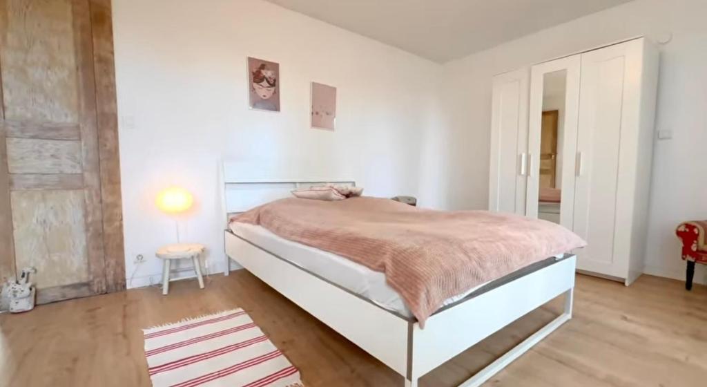 a bedroom with a bed in a white room at La chambre clé de la forêt in Métairies-Saint-Quirin