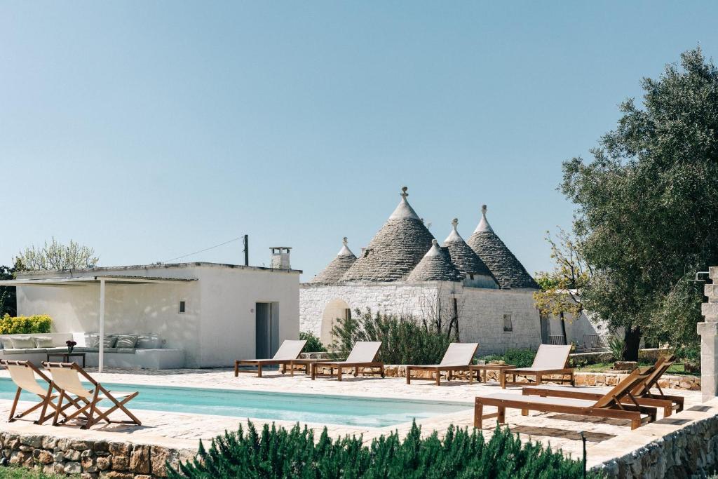 a villa with a swimming pool and a resort at Trullo dei Cinque in Cisternino
