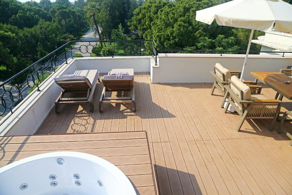 een terras met een hot tub en tafels en stoelen bij Perge Pine Green Adults Only 18 Plus in Antalya