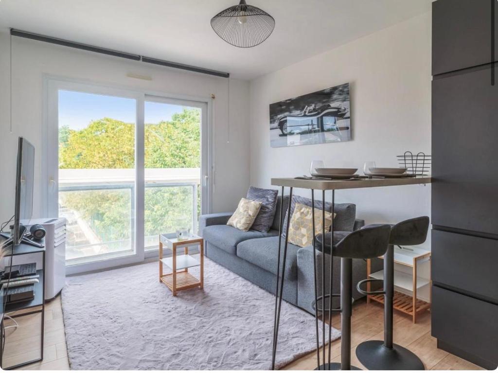 un salon avec un canapé et une table dans l'établissement Appartement t2 pour 4 avec parking, à Tasdon