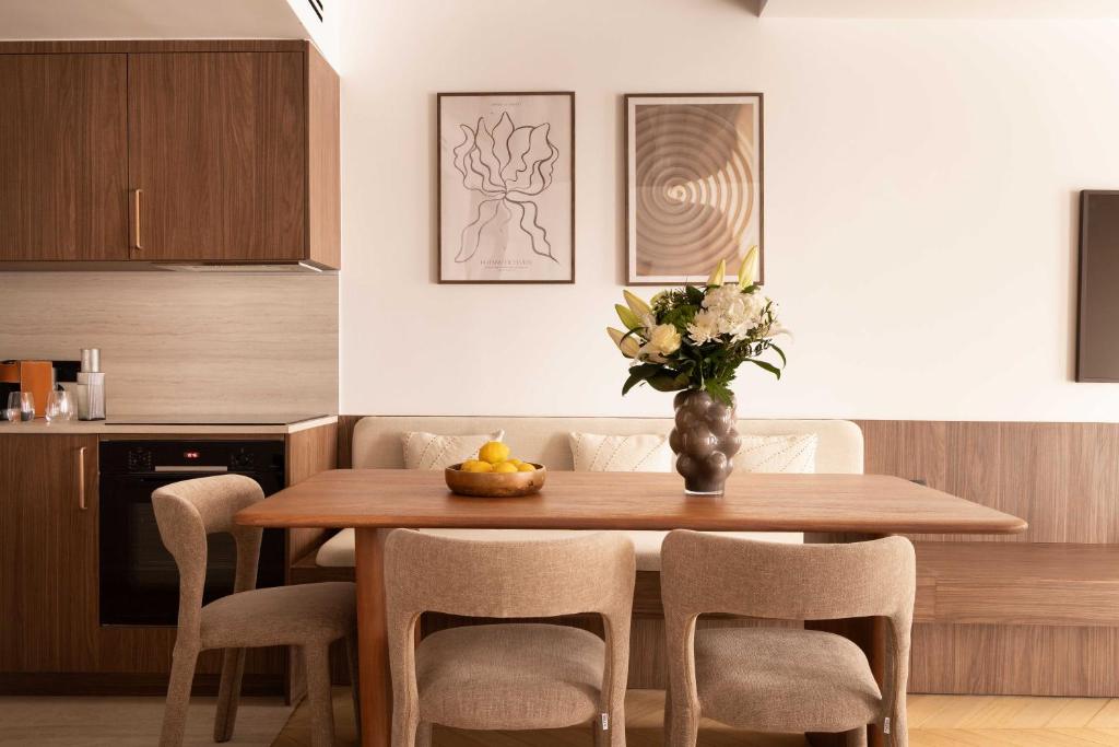 une table à manger avec des chaises et un vase de fleurs dans l'établissement chic A C central apt - 2bdr 6p - faubourg s denis, à Paris