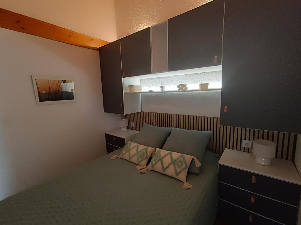 une petite chambre avec un lit et une fenêtre dans l'établissement maison mitoyenne dans residence de vacances, à Soulac-sur-Mer