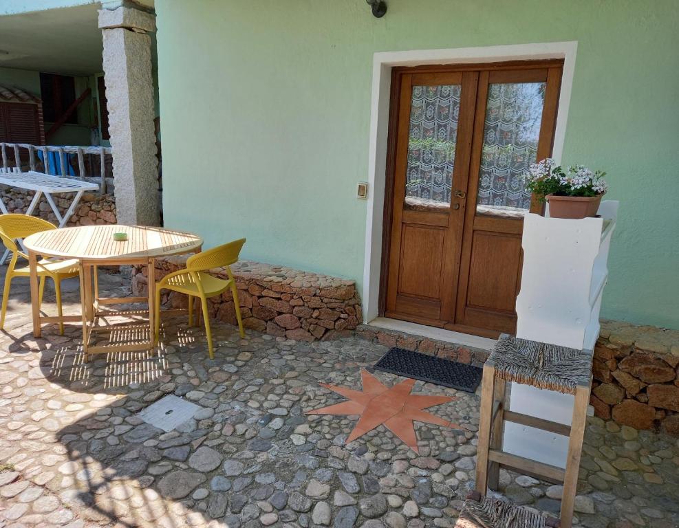 a patio with a table and chairs and a wooden door at B&B La Taerra in Porto San Paolo