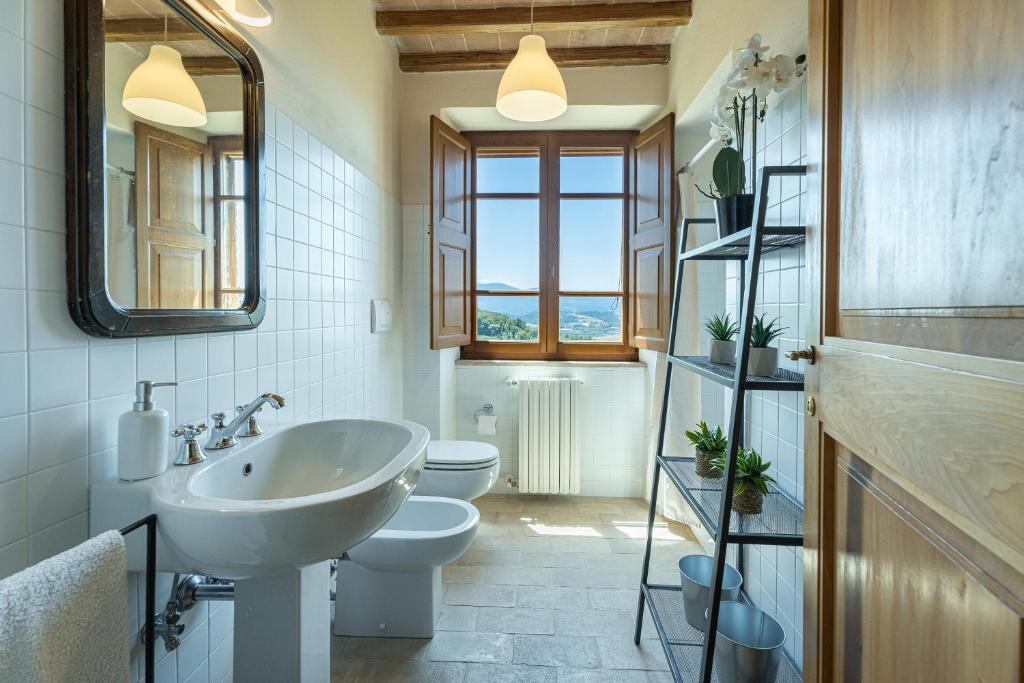 une salle de bains avec lavabo, toilettes et miroir dans l'établissement IL POGGIO ALLE TRESE 14, Emma Villas, à Città della Pieve 37 autres photos