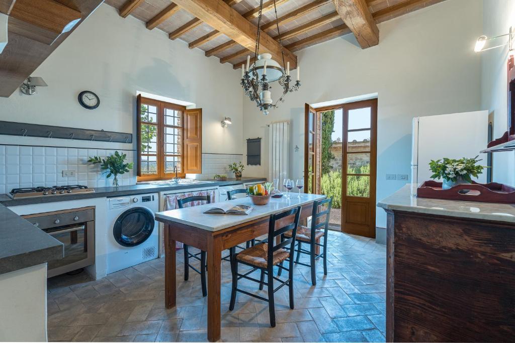 une grande cuisine avec une table et des chaises en bois dans l'établissement IL POGGIO ALLE TRESE 14, Emma Villas, à Città della Pieve