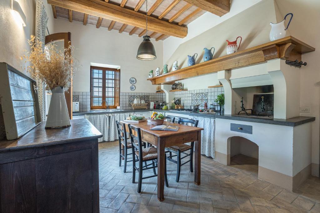 une grande cuisine avec une table et des chaises en bois dans l'établissement IL POGGIO ALLE TRESE 14, Emma Villas, à Città della Pieve