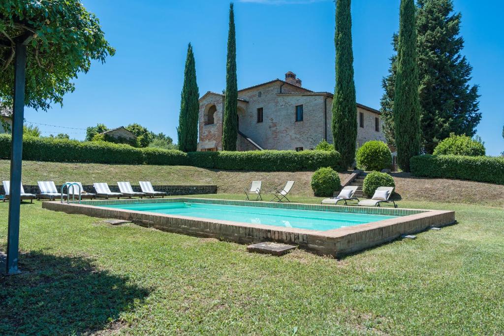 une piscine avec des chaises longues et une maison dans l'établissement IL POGGIO ALLE TRESE 14, Emma Villas, à Città della Pieve
