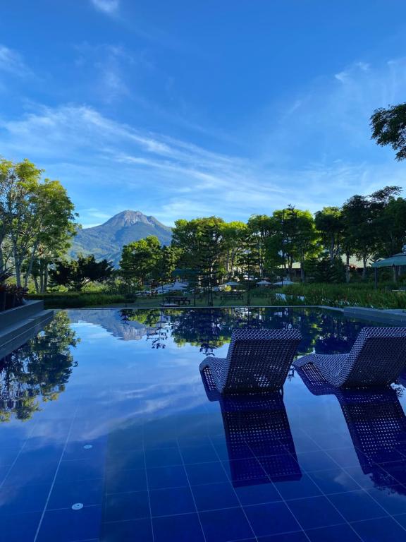 a swimming pool with two chairs in front of a mountain at Altamers Mountain Resort 