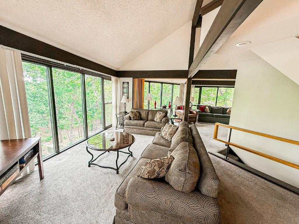 una sala de estar con un sofá y una mesa en Lakefront Treetop Village59-3bed3bapools-8pp, en Four Seasons