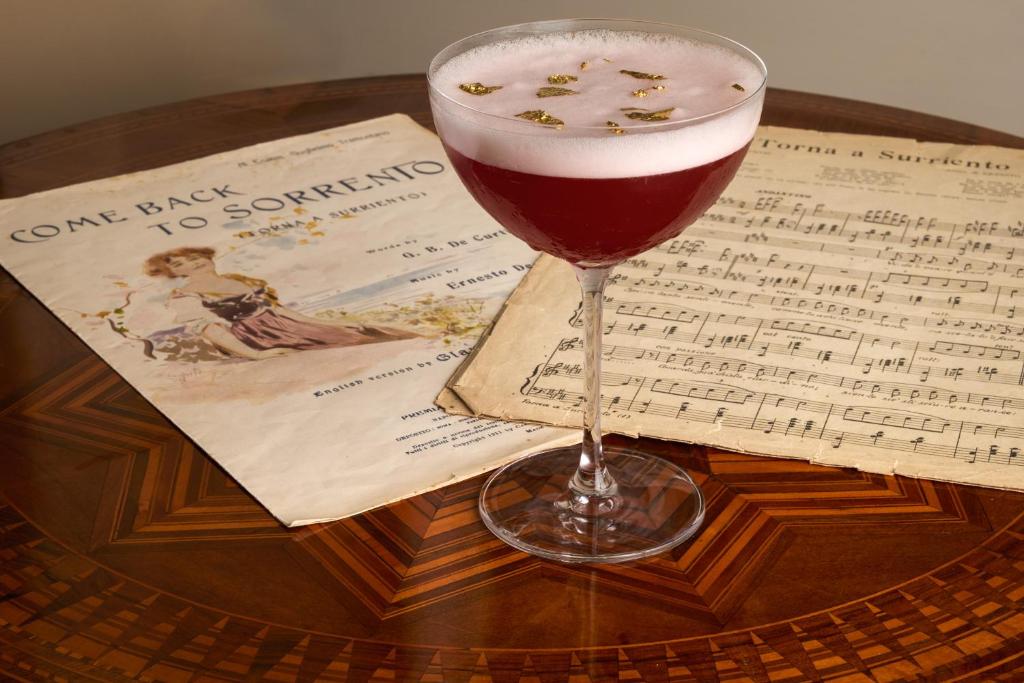 a glass of wine sitting on a table with music at Imperial Hotel Tramontano in Sorrento