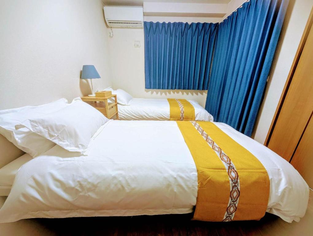 a bedroom with two beds and a blue curtain at 池袋本町101 in Tokyo