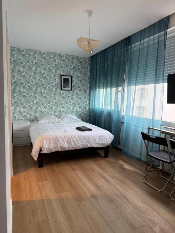 une chambre avec un lit et une table avec une chaise dans l'établissement M111 Marquer Joli studio, à Annemasse
