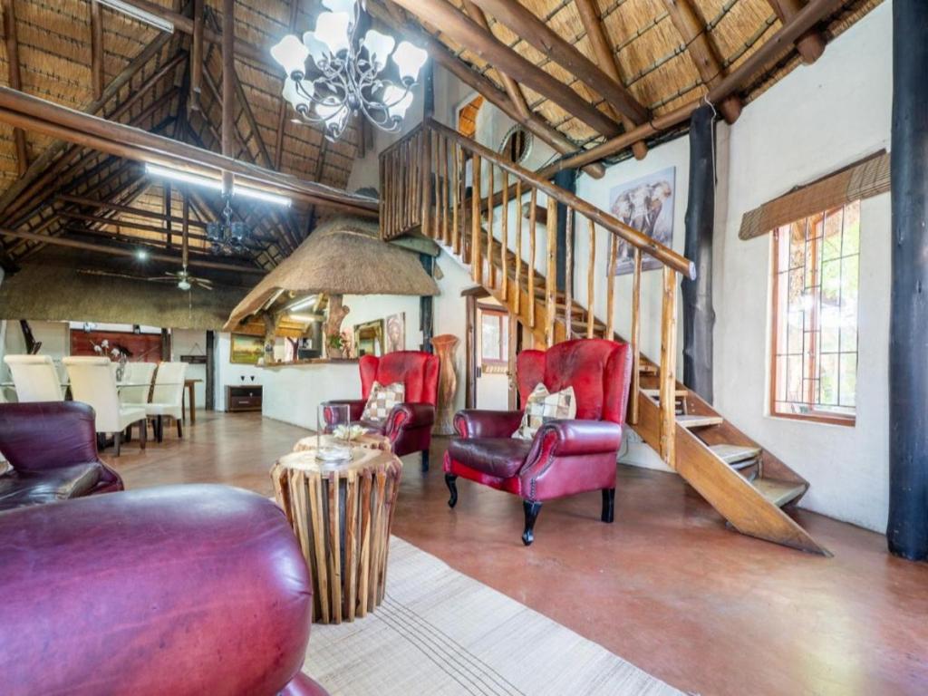 - un salon avec des chaises rouges et un escalier dans l'établissement Comfort Zone Guesthouse, à Veldenvlei