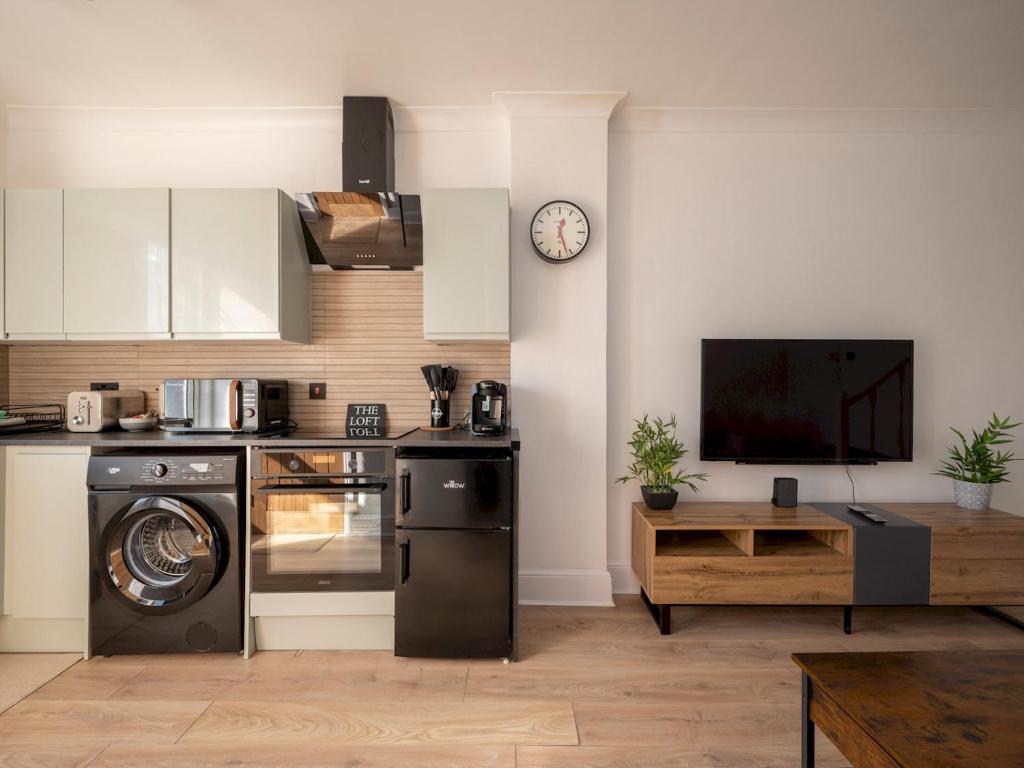 cocina con fogones y lavavajillas en Pass the Keys Stylish Croydon apartment - Central London links, en Croydon