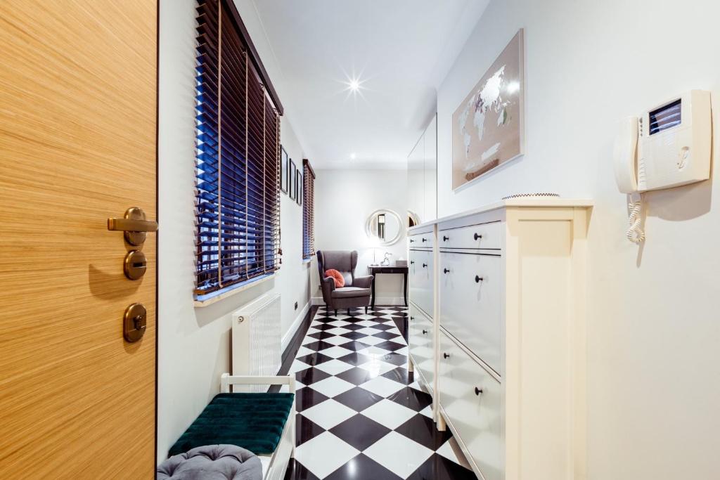 - une cuisine avec un sol en damier noir et blanc dans l'établissement Sunny apartment by the sea with garage, à Sopot