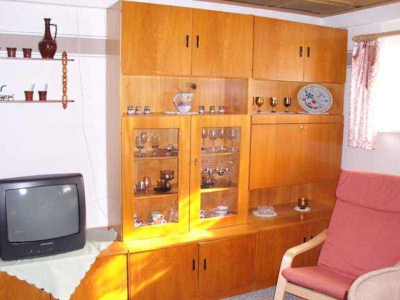 a living room with a tv and a wooden cabinet at Ferienwohnung Holst in Güstrow