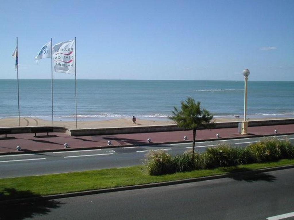 une route avec deux drapeaux au bord d'une plage dans l'établissement Bel Appartement T3, Vue Mer, 2 Chambres - FR-1-331-65, à Les Sables-dʼOlonne