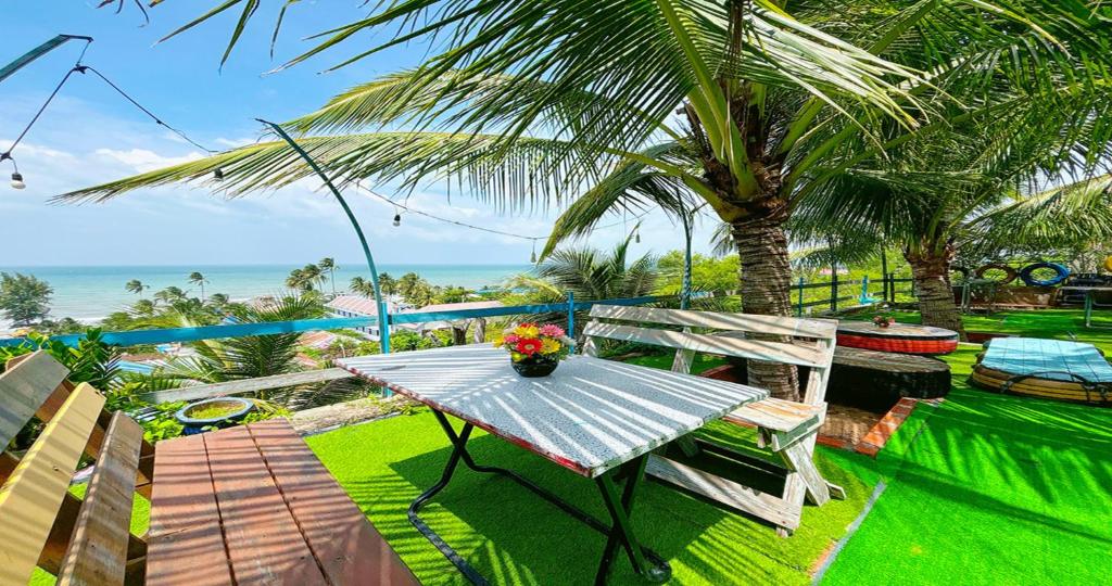a table and chairs on a balcony with a view of the ocean at Quoc Dinh Guest House in Mui Ne