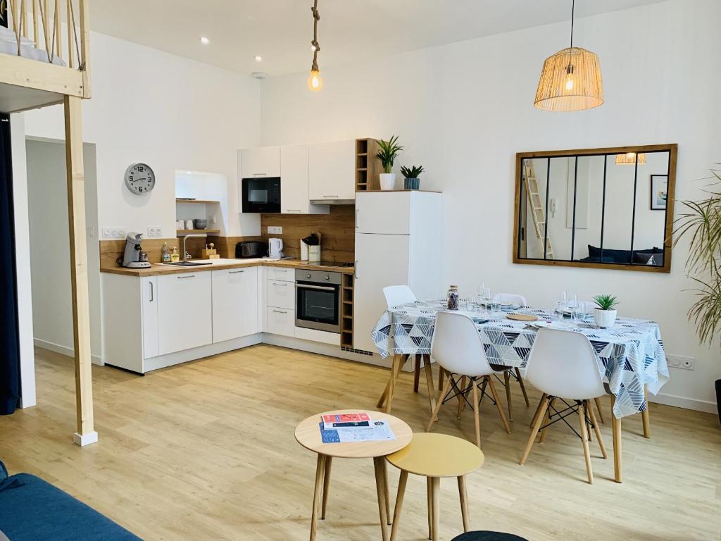 une cuisine et une salle à manger avec une table et des chaises dans l'établissement Le Saint Claude, refait a neuf, à La Rochelle