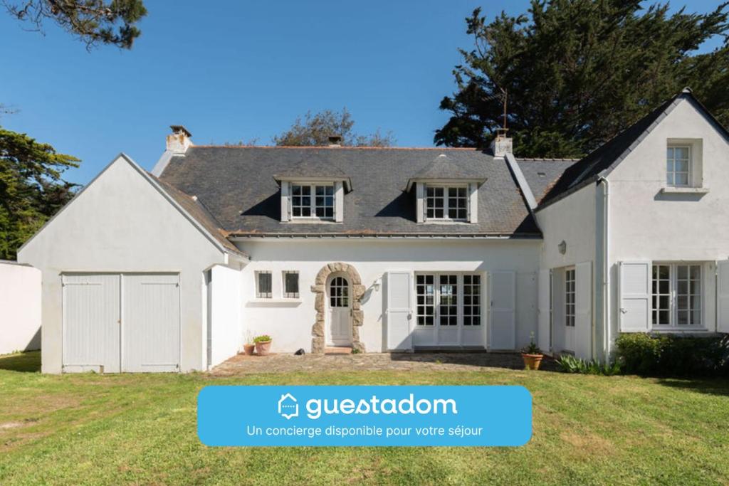a white house with a black roof at Villa du Mene - 60m plage & mer - Wifi in Mesquer