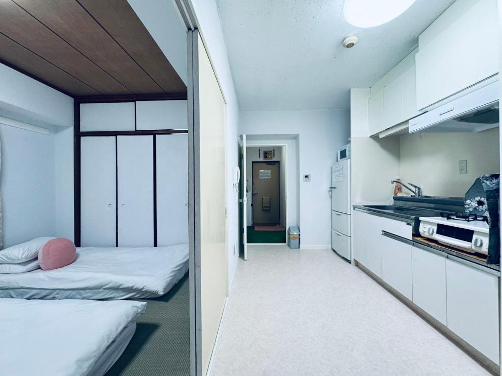 a small room with two beds and a kitchen at Ikebukuro-hostel池袋中川301&501 in Tokyo
